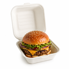 6x6 bagasse burger box filled with a gourmet cheeseburger, lettuce, tomato, pickles and red onion on a white background.