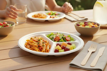 Food Packaging Direct 10-inch compostable bagasse 3-compartment round plates served with a meal on a wooden table.