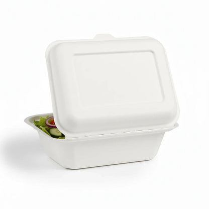 Food Packaging Direct 7x5 inch white bagasse clamshell lunch box containing fresh salad on a white background