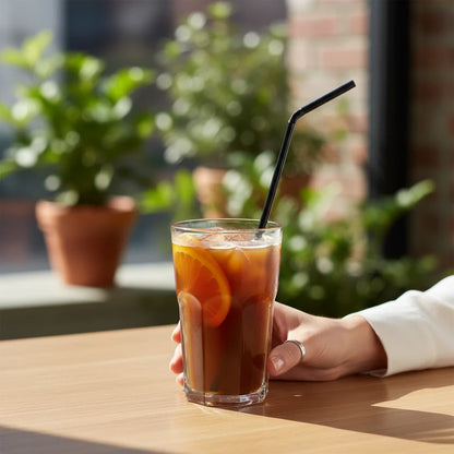 Food Packaging Direct black compostable flexi PLA straw in a glass of iced coffee with an orange slice